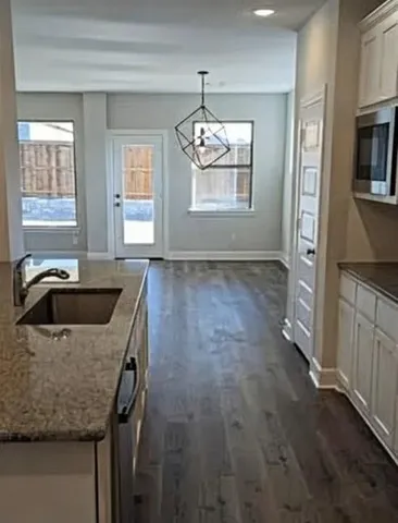 a kitchen that has a sink and a stove top oven