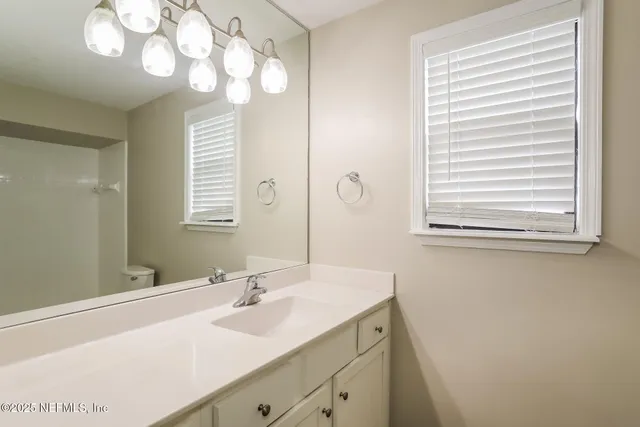 a bathroom with a sink a mirror and a window