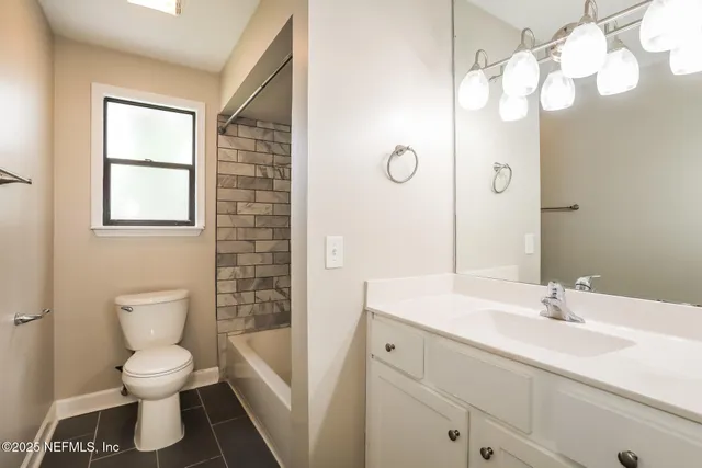 a bathroom with a sink a toilet and a large mirror