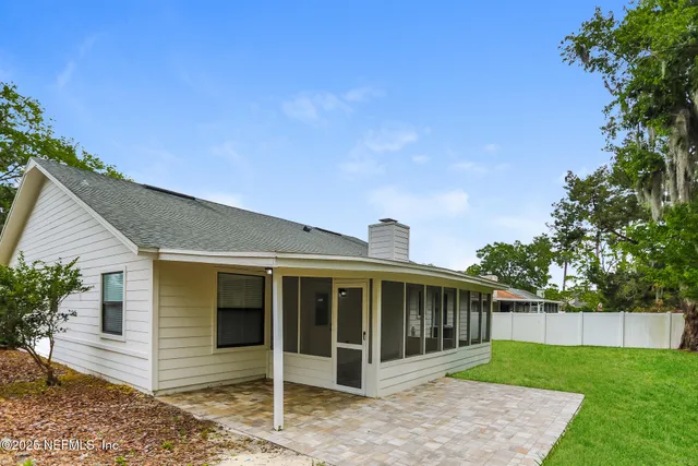 a view of a house with a yard and potted plants