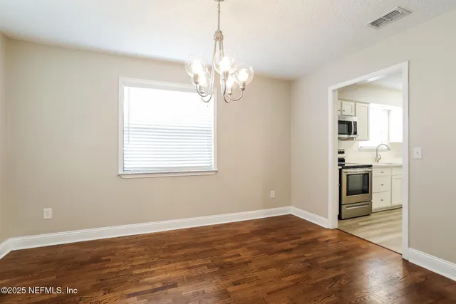 a view of a kitchen with wooden floor and a sink