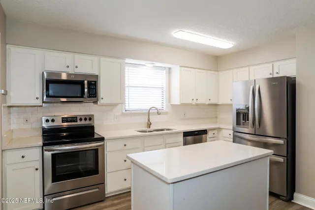 a kitchen with a white stove top oven and refrigerator