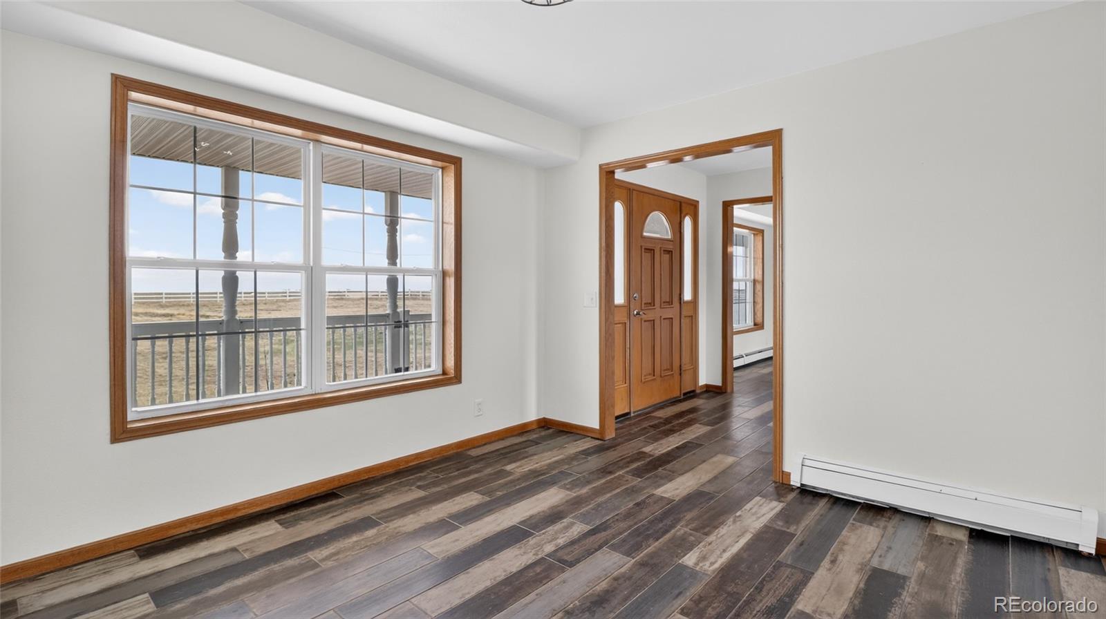 44166 East Iliff Trail Bennett, CO 80102 - Photo 16 of 50 a view of an empty room with wooden floor and a window