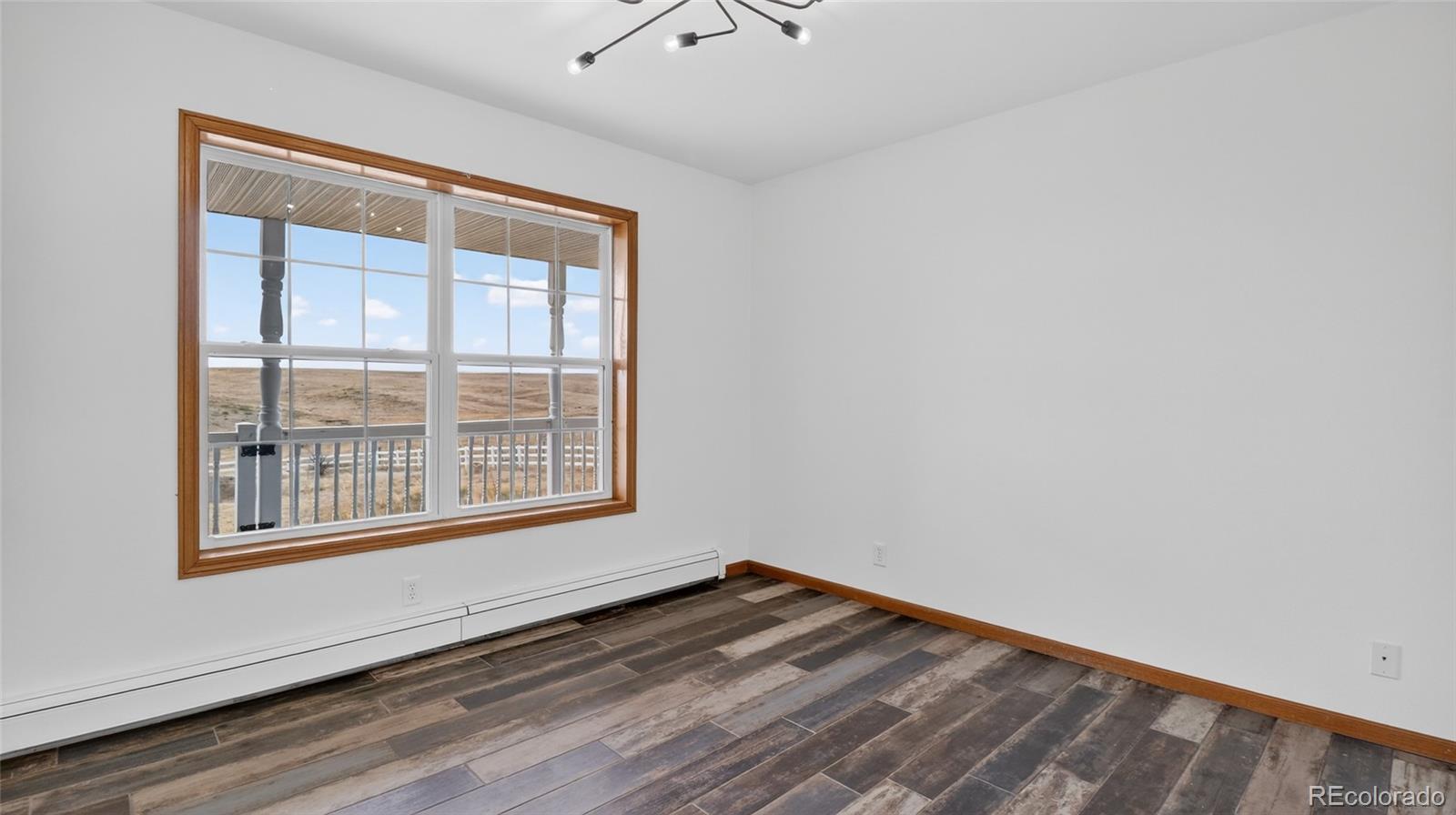 44166 East Iliff Trail Bennett, CO 80102 - Photo 19 of 50 a view of empty room with wooden floor and fan