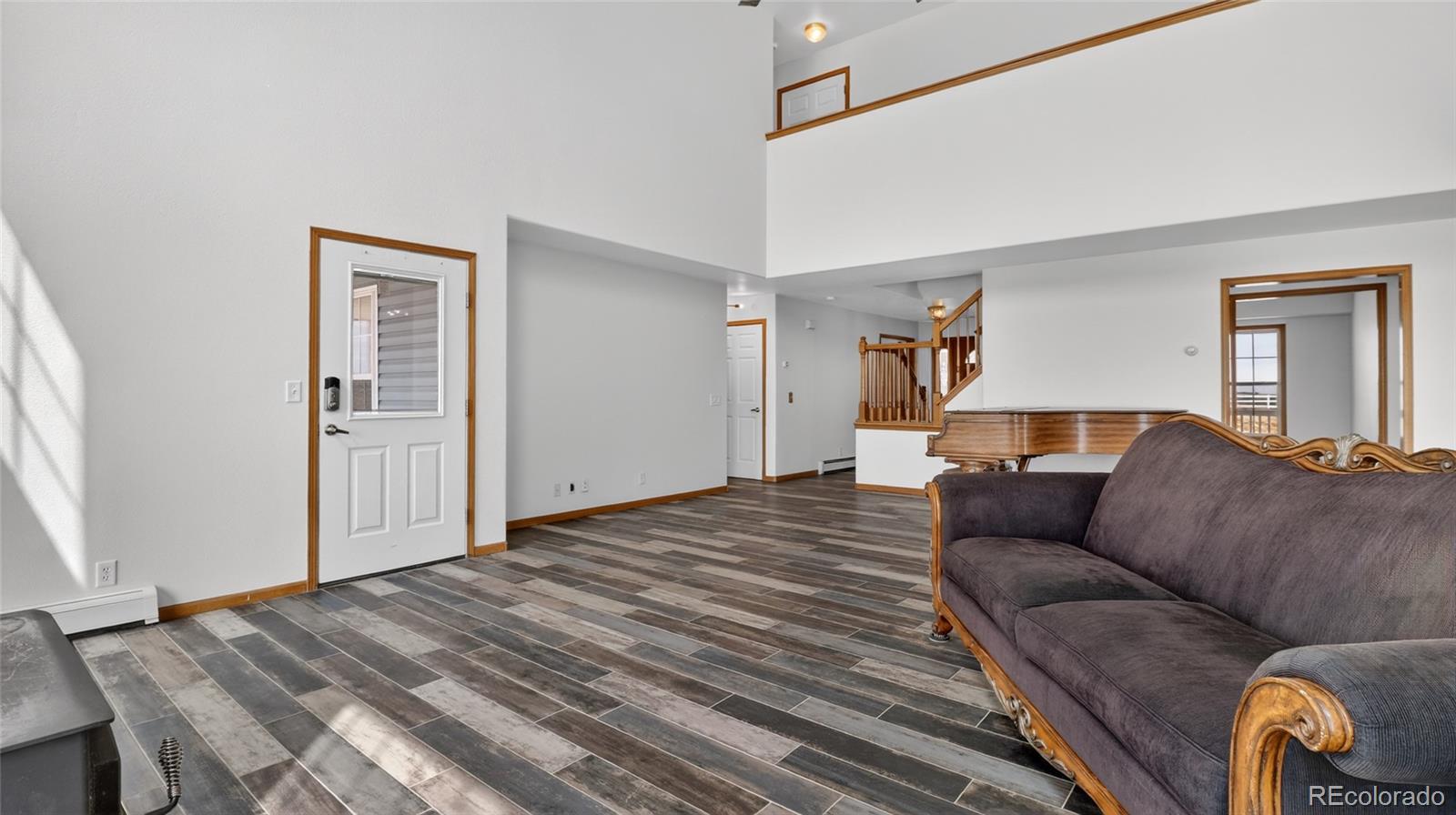 44166 East Iliff Trail Bennett, CO 80102 - Photo 21 of 50 a living room with a couch and wooden floor