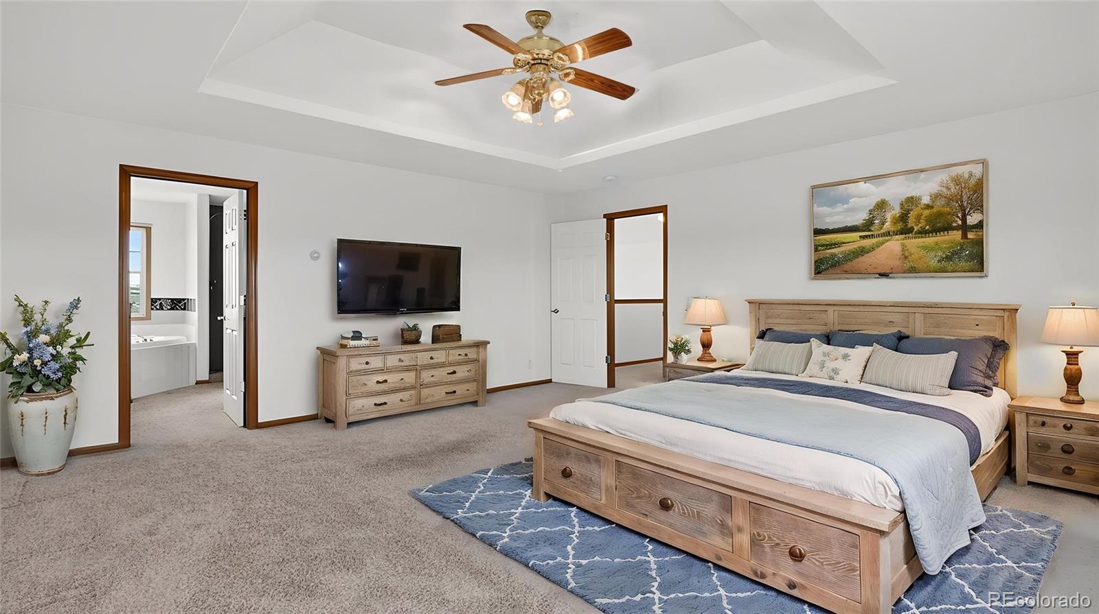 44166 East Iliff Trail Bennett, CO 80102 - Photo 23 of 50 a spacious bedroom with a bed and a flat screen tv
