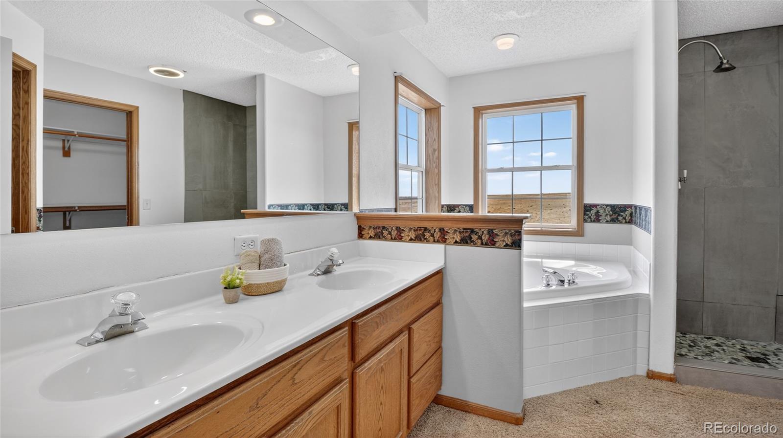 44166 East Iliff Trail Bennett, CO 80102 - Photo 26 of 50 a bathroom with a granite countertop sink and a mirror