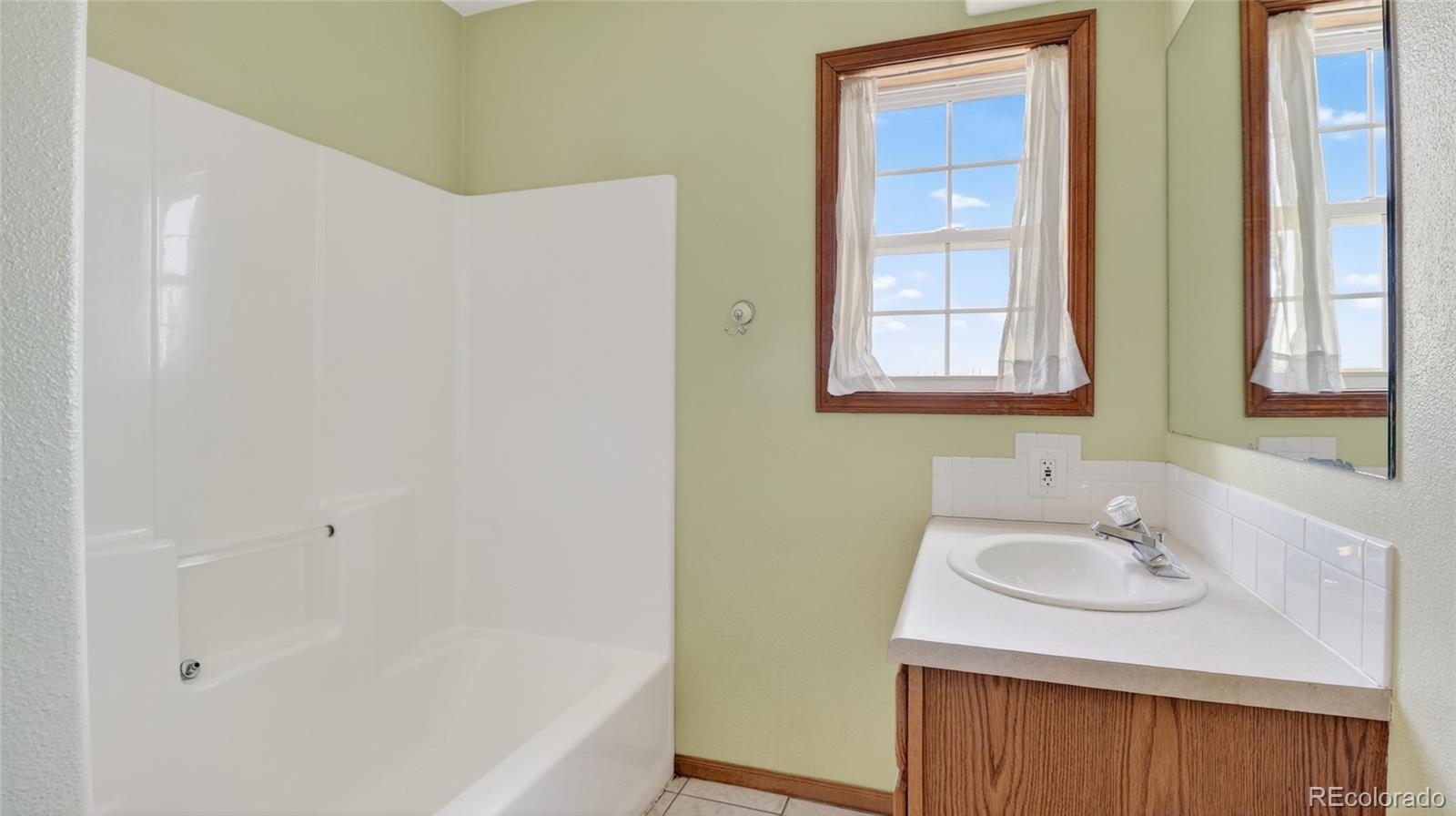 44166 East Iliff Trail Bennett, CO 80102 - Photo 32 of 50 a bathroom with a sink and a bathtub