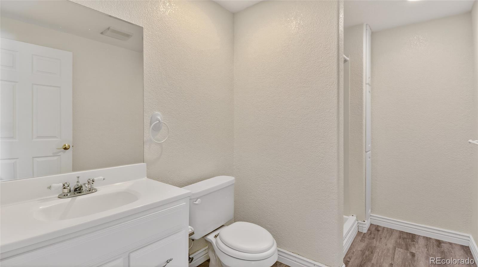 44166 East Iliff Trail Bennett, CO 80102 - Photo 36 of 50 a bathroom with a sink a toilet and vanity