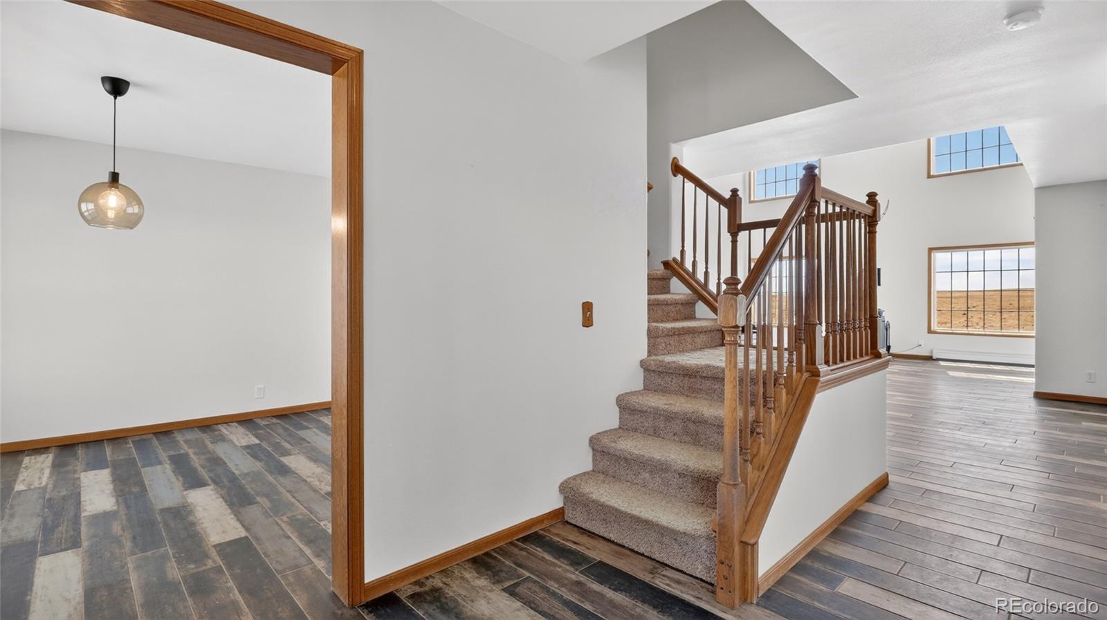 44166 East Iliff Trail Bennett, CO 80102 - Photo 8 of 50 a view of a hallway with wooden floor and staircase