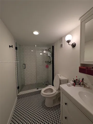 a bathroom with a sink a toilet a shower and a mirror