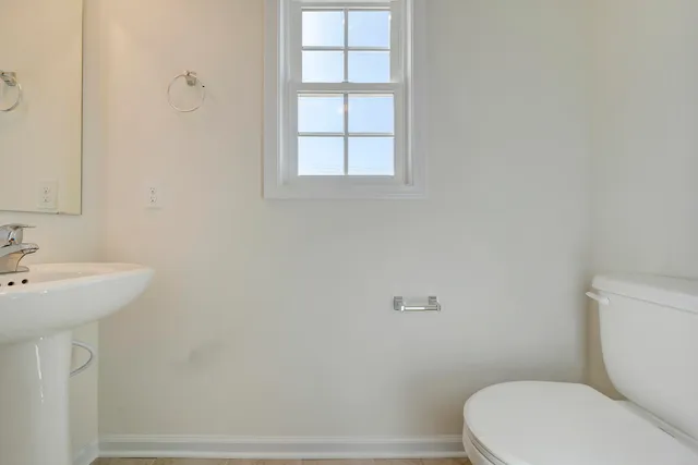 a white toilet sitting next to a bathroom sink