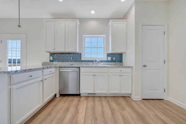 a kitchen with cabinets appliances a sink and a window