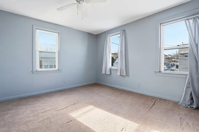 an empty room with a ceiling fan and a window