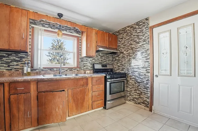 a kitchen with stainless steel appliances granite countertop a stove sink and cabinets