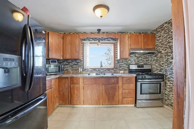 a kitchen with stainless steel appliances granite countertop a sink stove and refrigerator