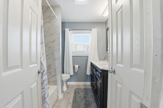 a bathroom with a sink a toilet and shower