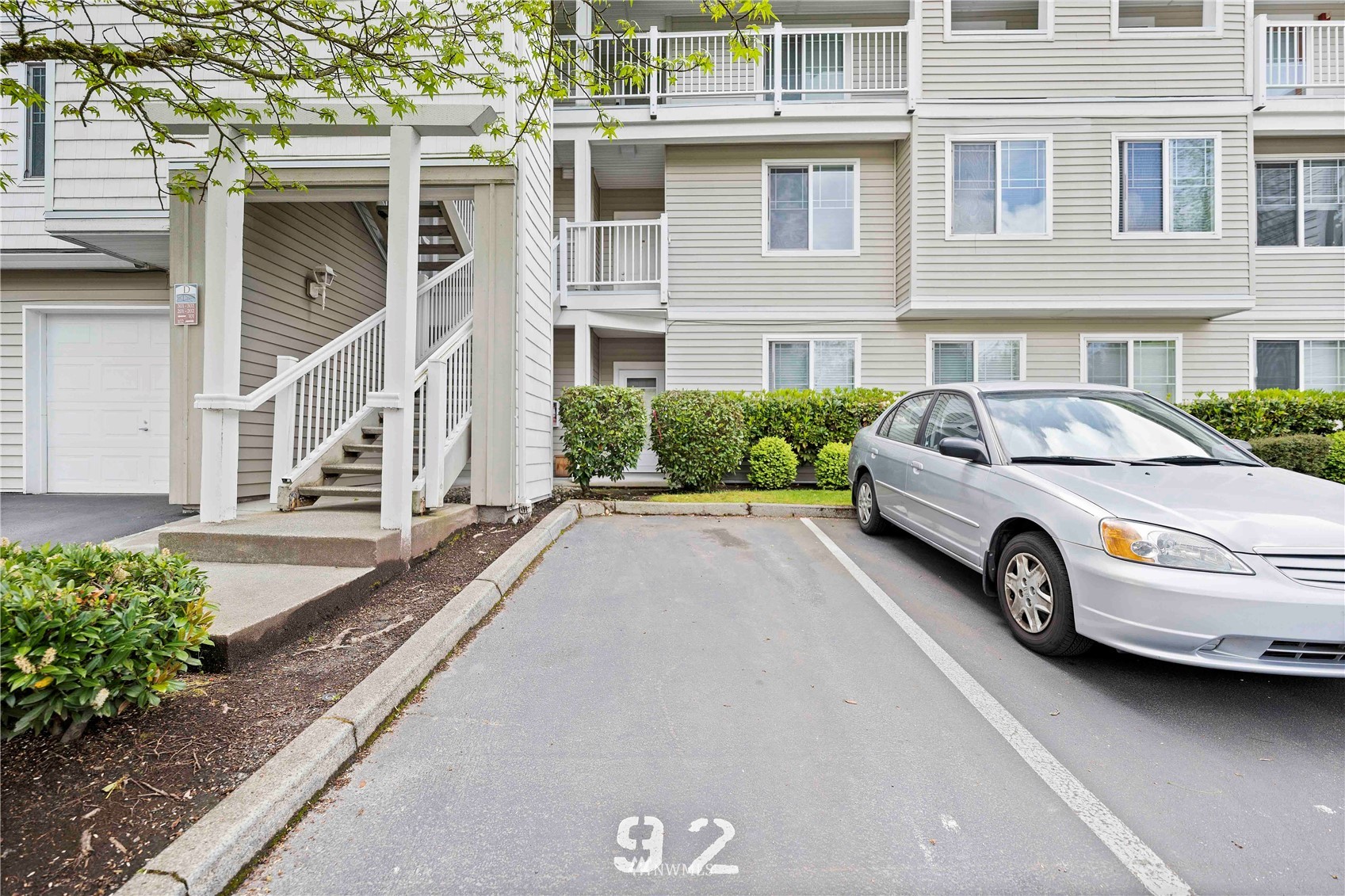 2009 196th Street Southeast, Unit D201 Bothell, WA 98012 - Photo 30 of 30 a view of a white house with a yard and parking space