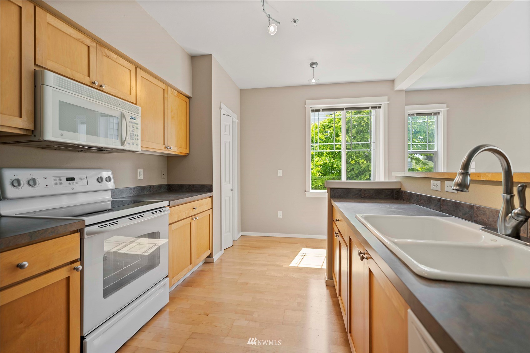 2009 196th Street Southeast, Unit D201 Bothell, WA 98012 - Photo 3 of 30 a kitchen with stainless steel appliances granite countertop a sink and a stove next to a window