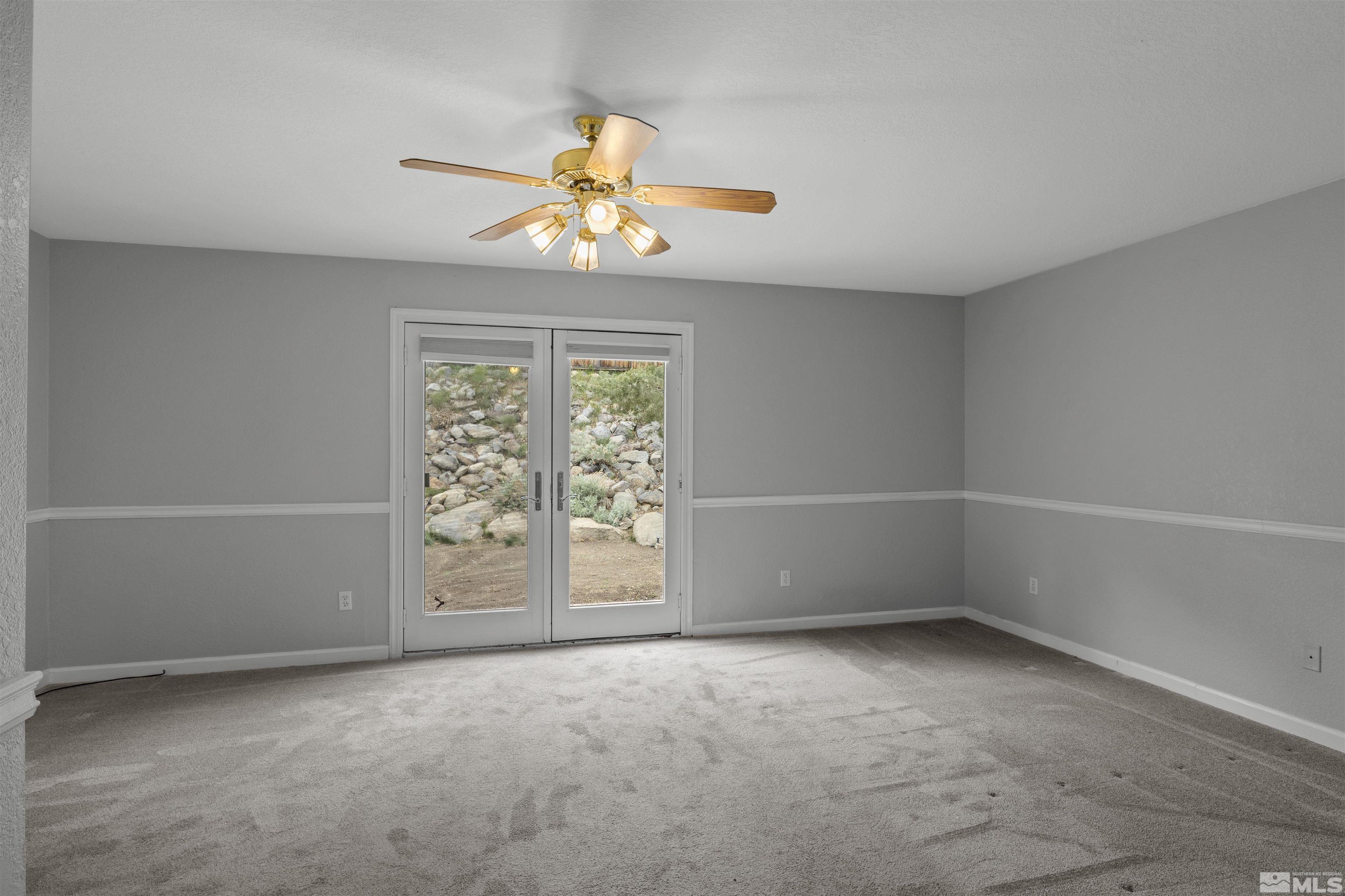 1990 Honey Ridge Drive Reno, NV 89511 - Photo 14 of 24 an empty room with windows and chandelier fan