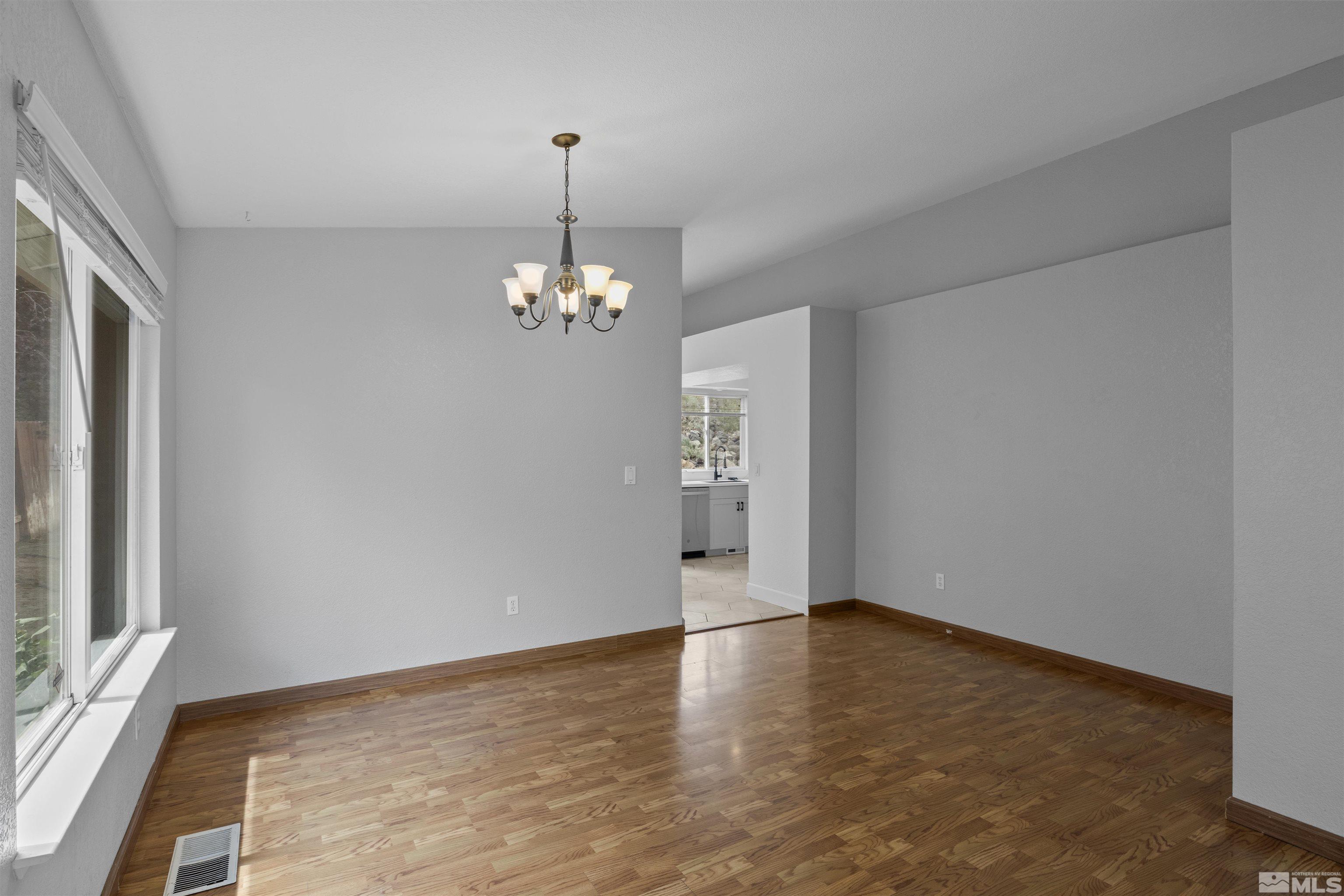1990 Honey Ridge Drive Reno, NV 89511 - Photo 6 of 24 a view of an empty room with wooden floor and a window