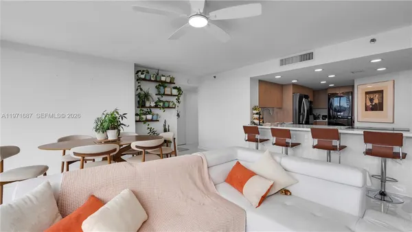 a living room with furniture kitchen view and a potted plant