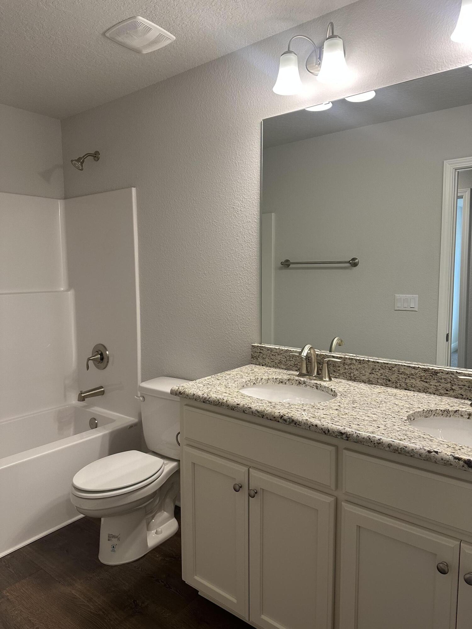 329 Keswick Lane Crestview, FL 32536 - Photo 13 of 22 a bathroom with a granite countertop toilet a sink and a bathtub