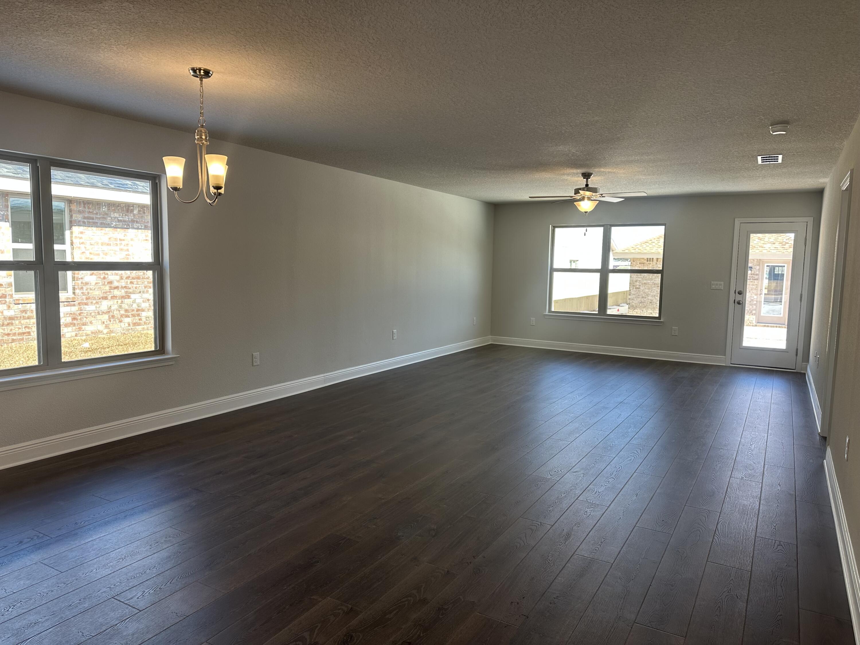 329 Keswick Lane Crestview, FL 32536 - Photo 9 of 22 an empty room with wooden floor and windows