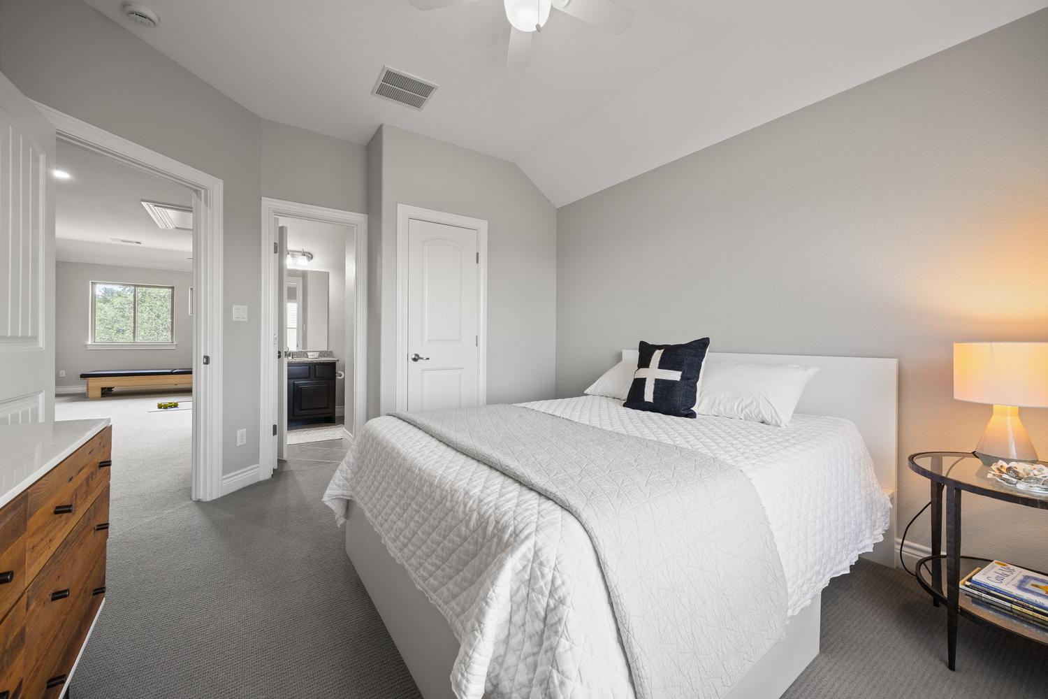1135 Blue Ridge Drive Dripping Springs, TX 78620 - Photo 22 of 36 A well-appointed bedroom features vaulted ceilings and soft carpet, offering peaceful repose.