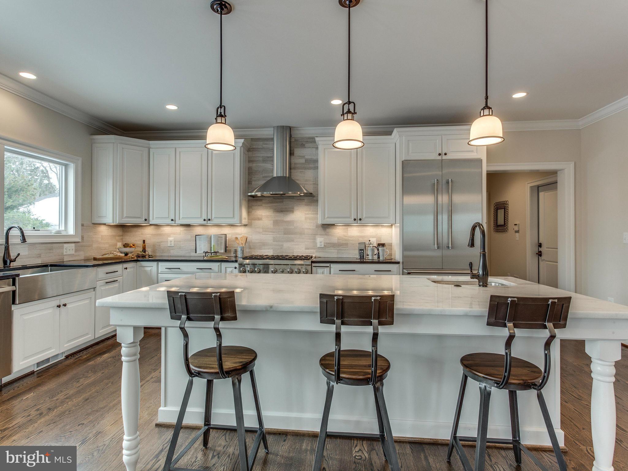 3100 North Rochester Street Arlington, VA 22213 - Photo 11 of 30 a kitchen with stainless steel appliances kitchen island granite countertop a dining table chairs and white cabinets