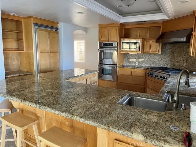 a kitchen with granite countertop a sink a counter top space appliances and cabinets