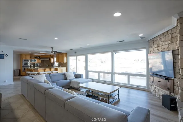 a living room with furniture a flat screen tv and a large window