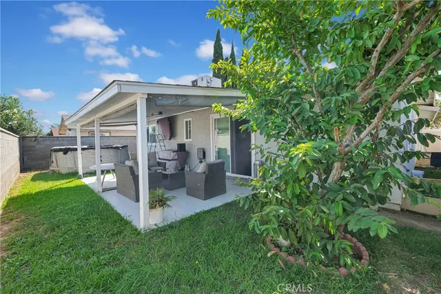 a view of a house with a yard potted plants and large tree
