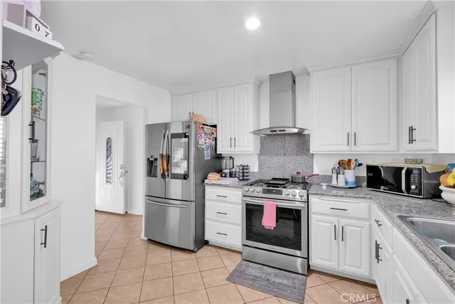 a kitchen with stainless steel appliances granite countertop a stove a refrigerator and a refrigerator