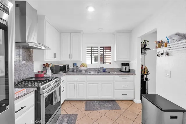 a kitchen with granite countertop a sink stove and cabinets