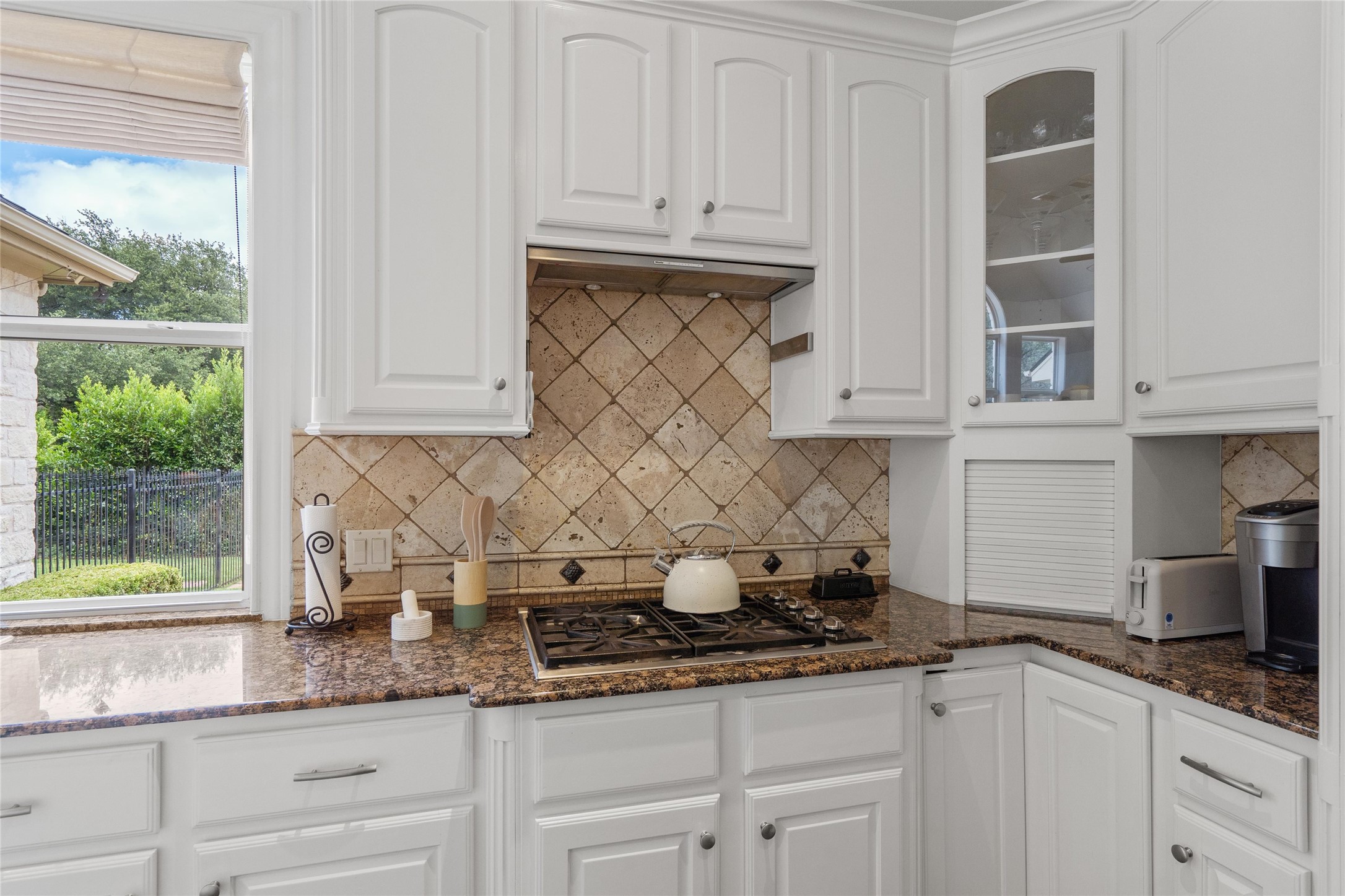 4313 Rio Robles Drive Austin, TX 78746 - Photo 15 of 40 Granite counters and white cabinetry complete this inviting, naturally illuminated kitchen space.