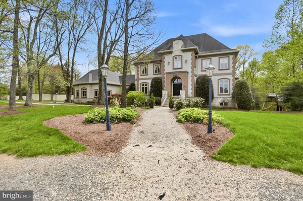 a front view of a house with a garden and trees
