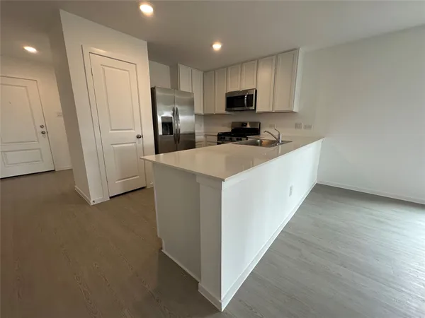 a kitchen with white cabinets and stainless steel appliances