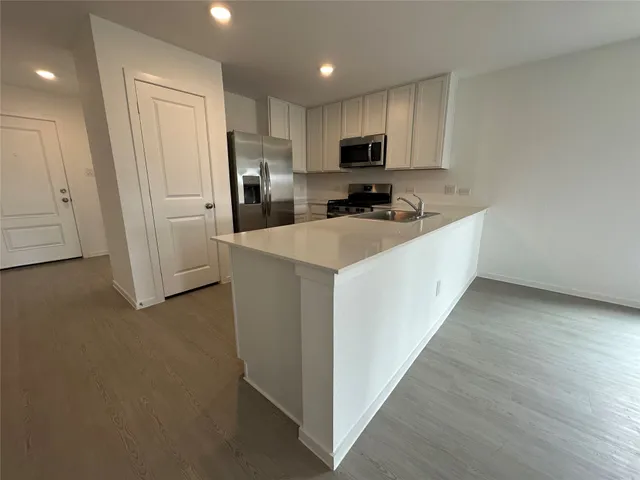 a kitchen with white cabinets and stainless steel appliances