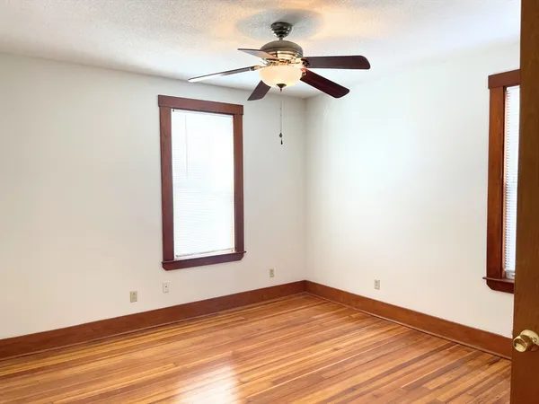 an empty room with a window and a ceiling fan