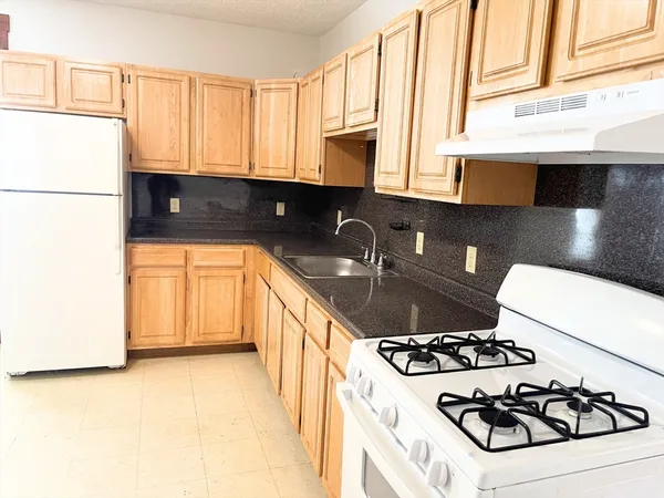 a kitchen with a sink a stove and cabinets