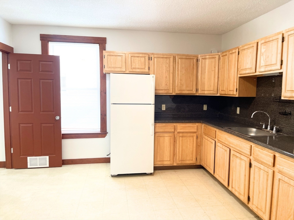 25 Bennett Street, Unit 2 Beverly, MA 01915 - Photo 10 of 17 a view of a kitchen with a sink dishwasher a refrigerator and cabinets