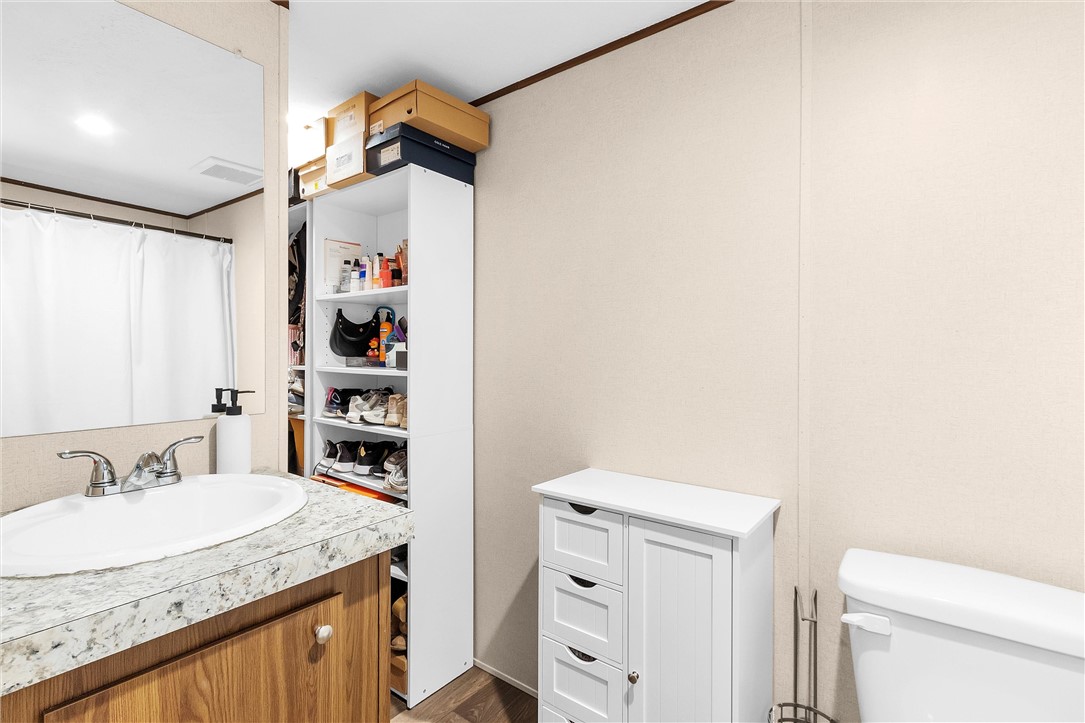 17708 Sweed Road Washington, TX 77880 - Photo 19 of 27 a bathroom with a granite countertop sink and a toilet