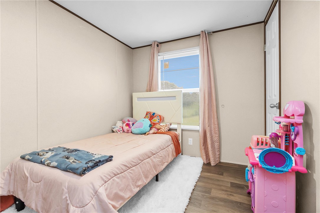 17708 Sweed Road Washington, TX 77880 - Photo 23 of 27 a bedroom with a bed and wooden floor