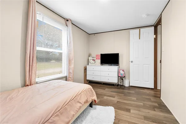 a room with a bed window and a flat screen tv