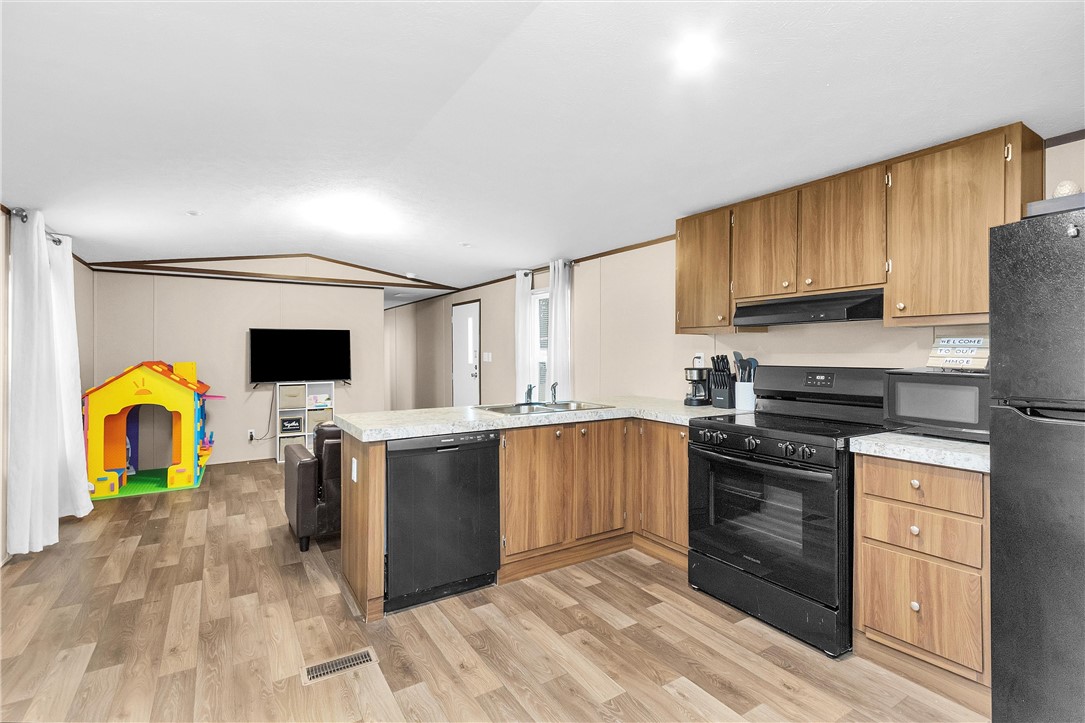 17708 Sweed Road Washington, TX 77880 - Photo 10 of 27 a kitchen with stainless steel appliances granite countertop a stove top oven a sink dishwasher and a refrigerator with wooden cabinets