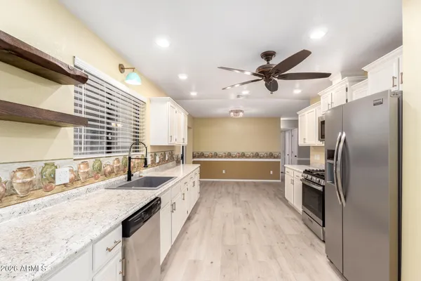 a kitchen with stainless steel appliances granite countertop a sink and a refrigerator
