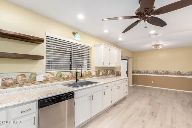 a kitchen with a sink stainless steel appliances cabinets and a large window