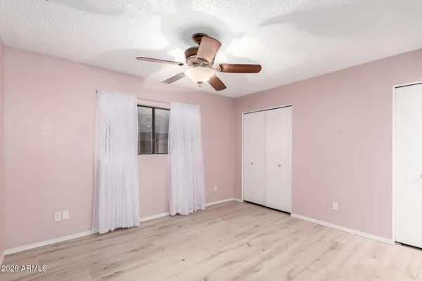 a view of a big room with wooden floor and a chandelier fan