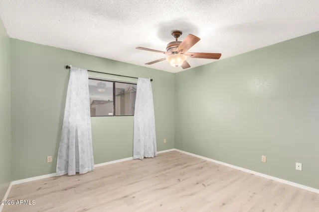 an empty room with fan and a ceiling fan